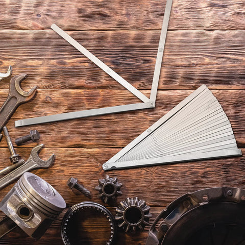 Tigeen 2-piece stainless steel feeler gauge set with 25 blades, metric and imperial scales, on wooden workbench.