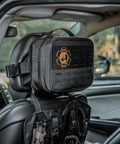 Vehicle IFAK Trauma Kit With CAT Tourniquet, Black Tactical First Aid Kit In MOLLE Pouch mounted on car headrest.