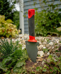 Heavy Duty Garden Trowel With Serrated Blade For Digging And Root Cutting Carbon Steel Hand Tool with red handle on soil