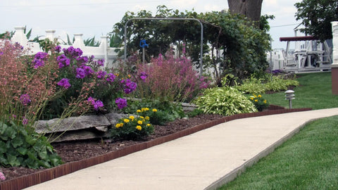 Garden bed with Brown Lawn And Landscape Border Edging For Garden Beds And Walkways With Flexible Design along a walkway.