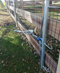 32-Inch Woven Wire Fence Stretcher With 3-Hook Bar Pro-Grade Galvanized Steel Construction attached to a fence for tensioning.