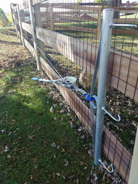 32-Inch Woven Wire Fence Stretcher With 3-Hook Bar Pro-Grade Galvanized Steel Construction attached to a fence for tensioning.