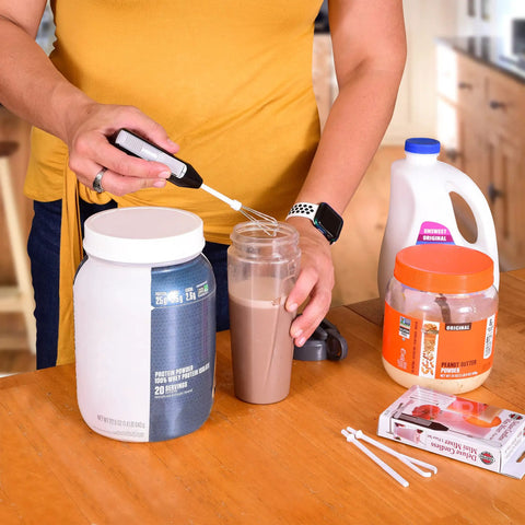 Portable Mini Mixer With Four Attachments For Beating Eggs Whipping Cream Mixing Dressings And Frothing Drinks in use blending a shake