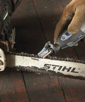 Using A679-02 Sharpening Attachment Kit for Outdoor Gardening Tools and Chainsaws on a chainsaw chain on wooden surface.