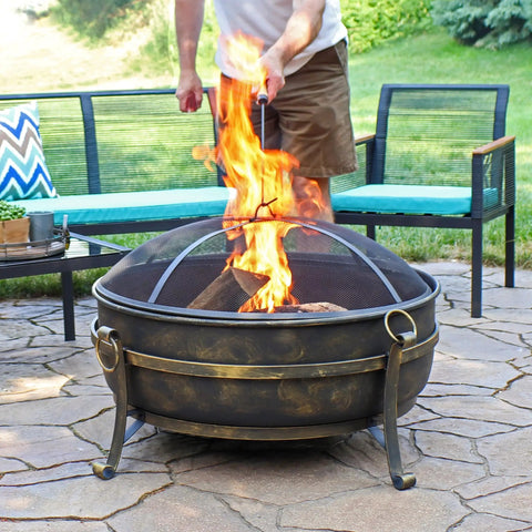 Outdoor 34 Inch Wood Burning Fire Pit Bowl with Spark Screen, Log Poker, and Grate used on patio.