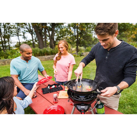 Group enjoying BBQ with Enamel Dinnerware Set For Outdoor Dining, 24-Piece Camp Kitchen includes plates, mugs, bowls, and silverware.