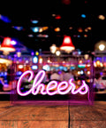 Neon Sign USB LED Light Up Bar Sign For Party Home Decor Desk Lightbox 3D Wall Neon Lamp with lit neon 'Cheers' text in front of bar.