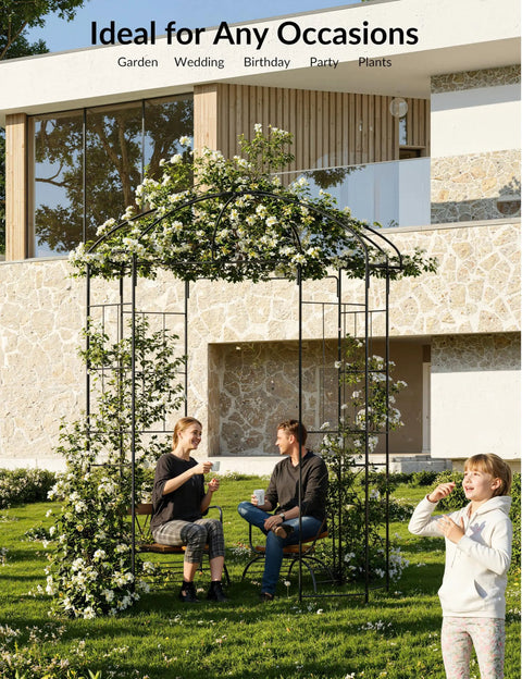 People under a 7 ft garden arch with gate, classic black finish, tough iron arbor for climbing roses and vines in a backyard setting.