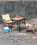 Heavy Duty Folding Table Risers 8 Pack Adjustable Leg Extenders For Straight And Bent Legs set up outdoors by a lake with chairs and food.