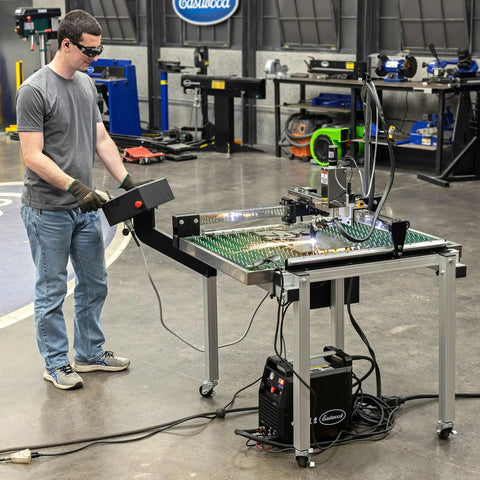 Person operating Versa-Cut 2 By 2 CNC Plasma Table For Metal Cutting With Garage-Grade Precision, LCD screen attached. Workshop setting.