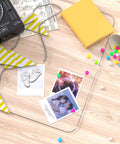 Wooden desk surface with scattered yellow books, colorful party decorations, and printed photographs.