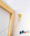 Heavy Duty Picture Hangers For Drywall And Plaster Walls, 75 Lb Earthquake Proof Hooks, close-up of gold hook on wall with frame