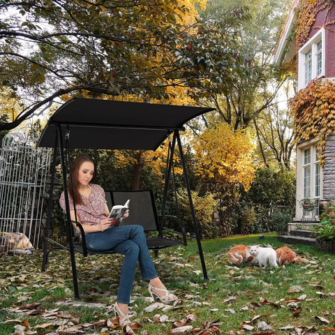 Woman sitting on a Two Person Porch Swing With Adjustable Canopy, Comfortable Fabric Seat And Heavy Duty Steel Frame in a garden