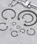 Five Pack Internal Retaining Ring Circlip Set 2.52 Inch Outer Diameter 2.25 Inch Inner Hole 0.08 Inch Thick 65Mn Spring Steel With Black Oxide Finish For Grooved Shafts And Studs displayed on grey surface with caliper