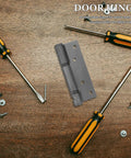 Self Closing Door Hinge Stainless Steel Hidden Design With Strong Spring For Wooden Doors Smooth Quiet Opening And 90 Degree Hold In High Traffic Kitchens Noise Reduction lying on wooden surface with tools and screws