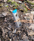 Ultralight Backpacking Trowel 0.48 Oz 13.5 G Blue With Lifetime Warranty in use for digging in forest soil.