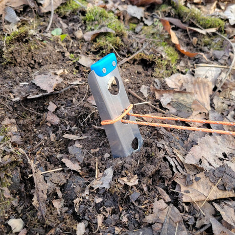 Ultralight Backpacking Trowel 0.48 Oz 13.5 G Blue With Lifetime Warranty in use for digging in forest soil.