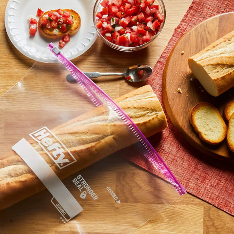 Jumbo 2.5 Gallon Storage Bags With Secure Zip And Click Closure Writable Label holding a baguette on a kitchen table.
