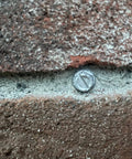 Close-up of Self Drilling Concrete Screws Quarter Inch By Three Inch Steel With Tungsten Carbide Tip installed in masonry.
