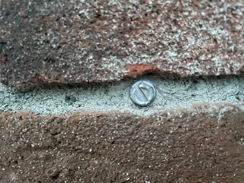 Close-up of Self Drilling Concrete Screws Quarter Inch By Three Inch Steel With Tungsten Carbide Tip installed in masonry.