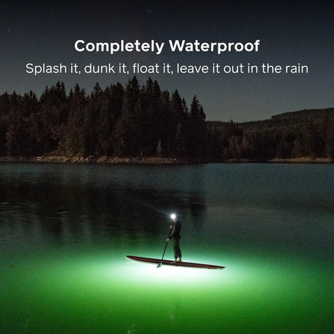 Person paddleboarding at night with Luci Original Solar Inflatable Camping Lantern With USB C Recharge illuminating the water.
