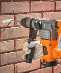 10 Amp Rotary Hammer Drill With Vibration Control Three Modes Demolition Kit in use on brick wall, showing drilling mode