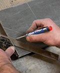 Hand using Pro Marker Holder With Graphite Lead And Built In Sharpener For Real Work, 1 Click Advance on metal surface