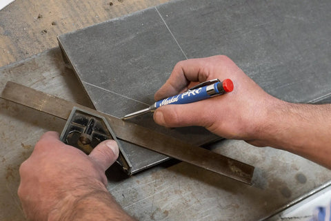 Hand using Pro Marker Holder With Graphite Lead And Built In Sharpener For Real Work, 1 Click Advance on metal surface