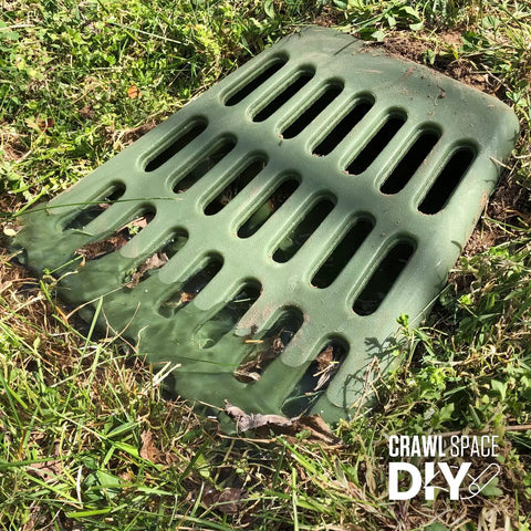Green ground-level grate for downspout and sump pump discharge extension, fits 3 or 4 inch pipe, in lawn setting
