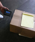 Digital Wireless Postal Scale With 330 Lb Capacity For Shipping And Packaging Industrial Grade Weighing Solution Battery And Adapter Included Beast For Post Offices Warehouses And Manufacturing Environments displaying weight of a package on a warehouse floor.