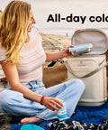 Carryout Cooler Backpack With All Day Cold Insulation And Portable Soft Build Trail And Park Friendly Features An Ergonomic Strap System 22 Liter Capacity In Shale Gray To Keep Your Stash Chill On The Go, beach setting, person using cooler.