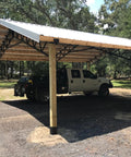 Open carport with wooden posts and steel roof using 4x4 Post Anchor Ground Spike Kit For Concrete Decks, Beefed-Up Steel With Black Powder Coat.