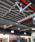 84 Inch Smart Outdoor Ceiling Fan With Wifi App Control And SenseMe Tech For Next Level Backyard Vibes Super High Velocity Modern Design In Refined Brushed Aluminum Frame in a bike store.