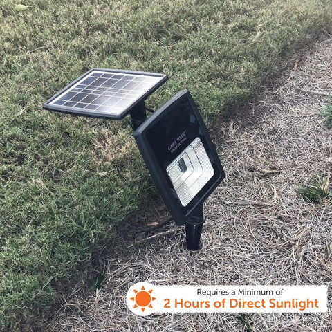 Outdoor Solar Flood Light in Black Cast Aluminum with Warm White 2700K LEDs staked in grass, detachable solar panel visible