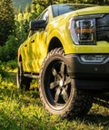Yellow truck with Trail Blade MTS Mud Terrain Radial Tire For Light Trucks And Jeeps, 35X13.50R24LT, off-road setting