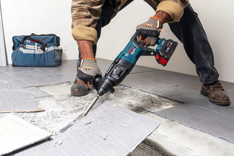 Worker using 5 In. By 11 In. SDS-Plus Bulldog Floor Scraper With Durable Steel Blade, Locking Bolt Attachment removing tiles