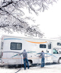 Two people using 12 Foot Heated Drinking Water Hose With Freeze Protection Down To Minus 40 Degrees on RV in snowy conditions