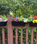Set Of Four Heavy Duty Metal Railing Planters, 16 Inch Rectangular Window Boxes with vibrant flowers on a balcony railing.