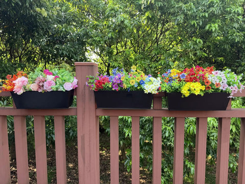 Set Of Four Heavy Duty Metal Railing Planters, 16 Inch Rectangular Window Boxes with vibrant flowers on a balcony railing.