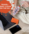 WHOOSH! Screen Shine Duo XL spray bottle with red cap and orange microfiber cloth beside laptop and smartphone.