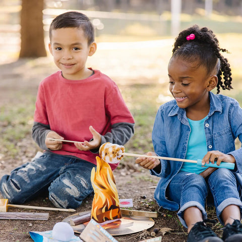 Children playing with Campfire S'mores Pretend Play Set With 23-Piece Toy Food Kit For Kids 3 Plus, including marshmallows and logs.