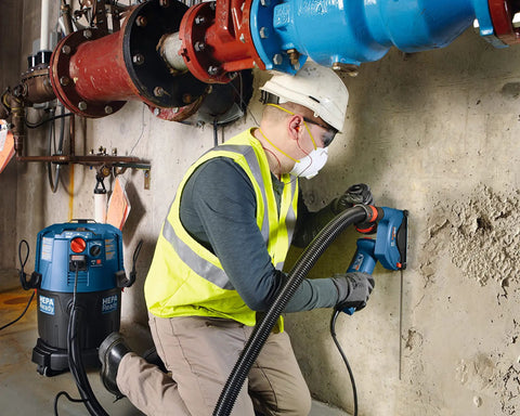 Worker in safety gear using diamond blade for cutting concrete, illustrating 14 Inch Standard Segmented Rim Diamond Blade With 1 Inch Arbor.