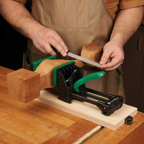 Rock Solid 6 Inch Quick Action Bench Vise With 300 Pound Clamping Power shown holding wood block with a file for shaping.