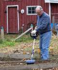 Man using Drill Powered Cultivator Attachment For Cordless Drills in garden, Model 46007, lightweight aluminum build, extendable length