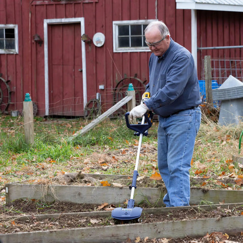 Man using Drill Powered Cultivator Attachment For Cordless Drills in garden, Model 46007, lightweight aluminum build, extendable length