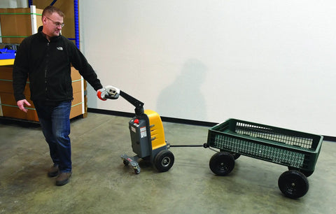 Heavy Duty Electric Powered Tugger With 1000 Lb Pull Capacity For Effortless Factory Material Handling, being operated in a warehouse.