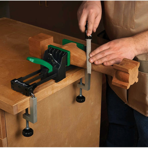 Rock Solid 6 Inch Quick Action Bench Vise With 300 Pound Clamping Power holding wooden block while sanding on workbench.