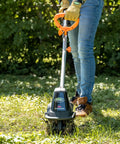 Person using 20V Cordless Garden Tiller Cultivator With 7.5 Inch Width, 6 Inch Depth, on grass, showing ease of use.