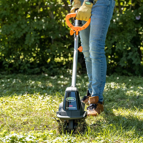 Person using 20V Cordless Garden Tiller Cultivator With 7.5 Inch Width, 6 Inch Depth, on grass, showing ease of use.