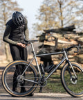 Cyclist adjusting a bike with adjustable 360mm bike cargo straps set for bikepacking, featuring TPU grip for securement on long rides.